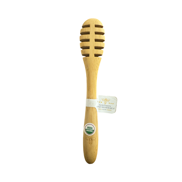 Bamboo honey dipper with a label on a white background