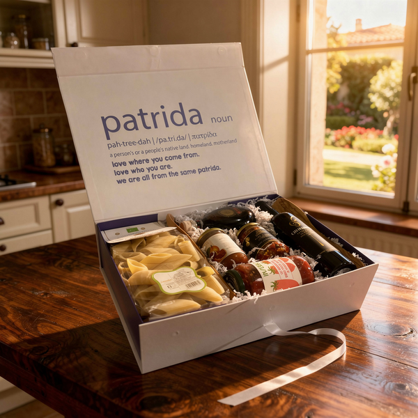 Gift box with olive oil, pasta, balsamic vinegar, blood orange marmalade, hot calabrian peppers and inserbo tomato sauce on a wooden table, with 'patrida' box.