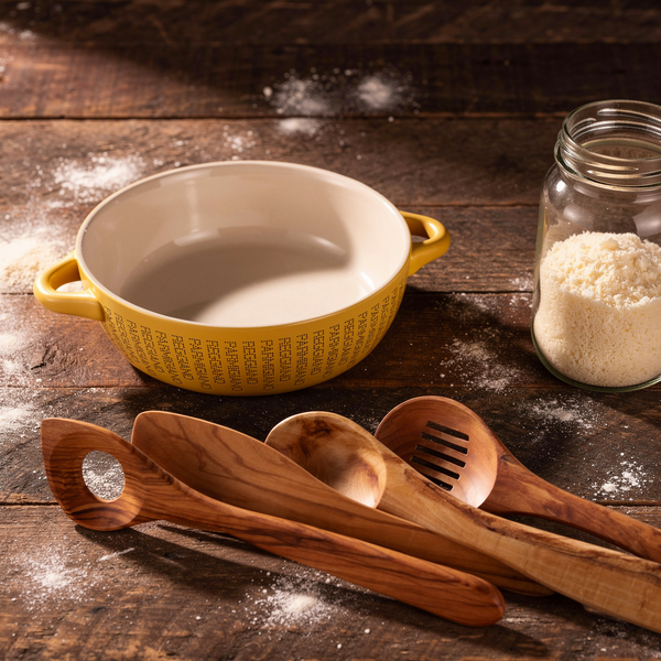 Yellow spagetti bowl with wooden utensils on a wooden surface