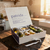 Box of patrida wine bottles on a wooden table in a kitchen setting