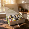 Box of patrida products on a wooden table with a kitchen background